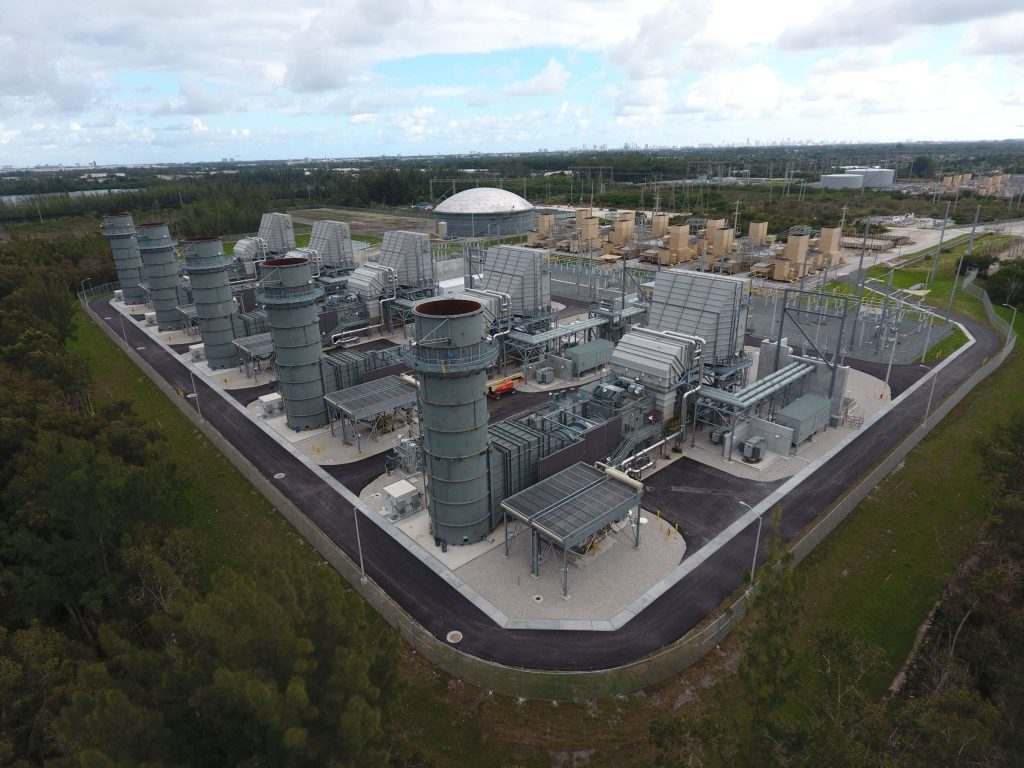 Aerial view of a natural gas turbine power plant with exhaust stacks and substation