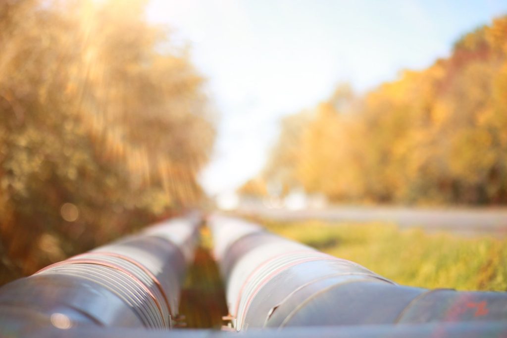 Above-ground natural gas pipeline running through autumn trees